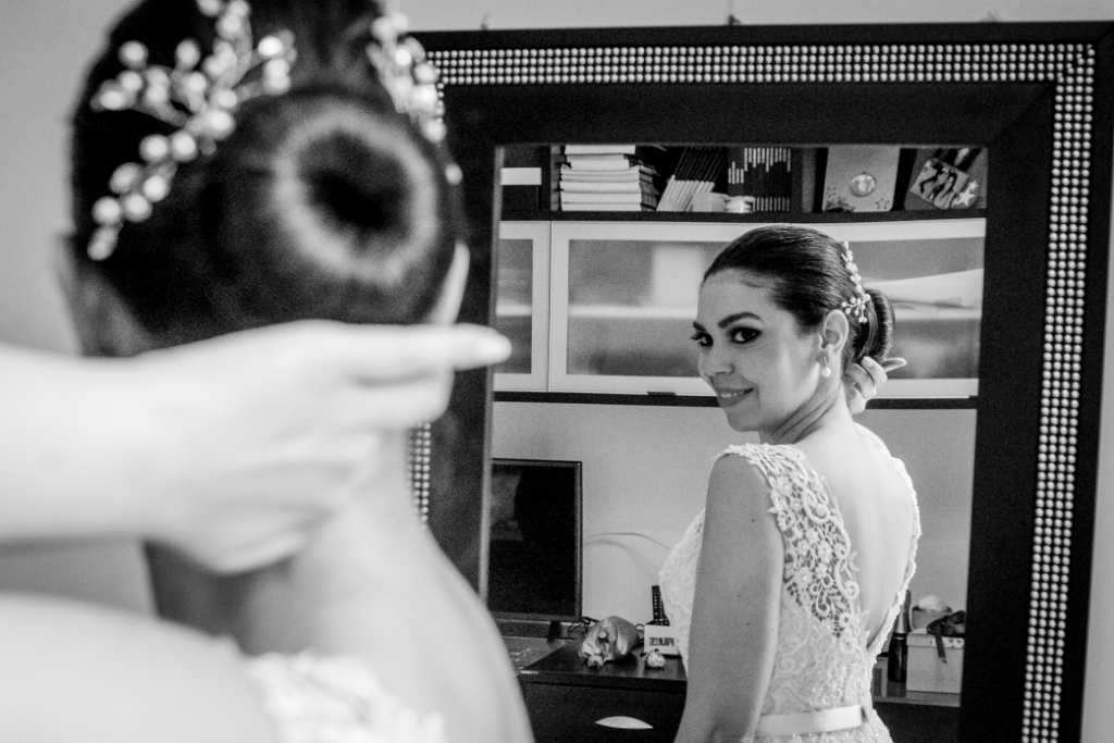 Making Of, fotografia PB, preparação da noiva, casamento em niterói, noiva passando perfume, noiva sorrindo, espelho, maquiagem, vestido da noiva, vestido branco, flor no vestido, stephanie cachapuz