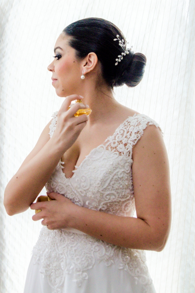Making Of, fotografia PB, preparação da noiva, casamento em niterói, noiva passando perfume, noiva sorrindo, espelho, maquiagem, vestido da noiva, vestido branco, flor no vestido, stephanie cachapuz