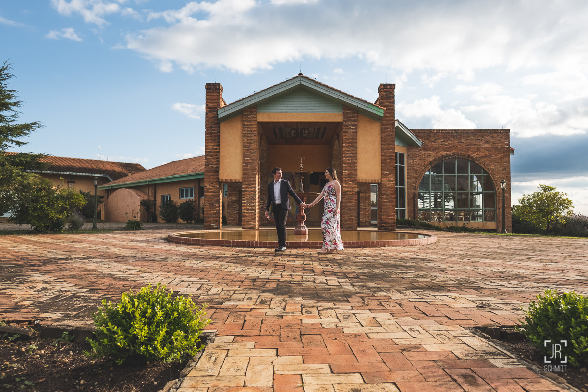 noivos de mãos dadas diante do chafariz
