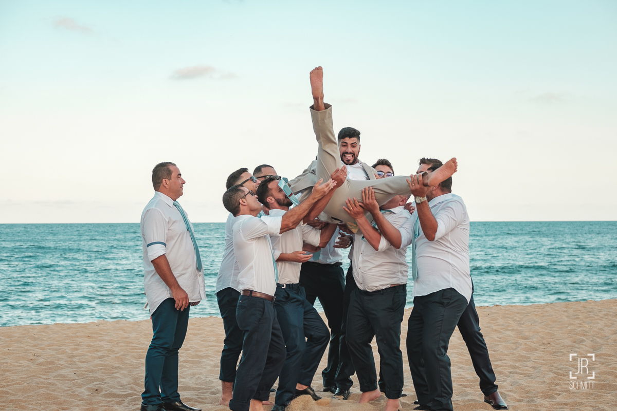 os padrinhos e o noivo na praia