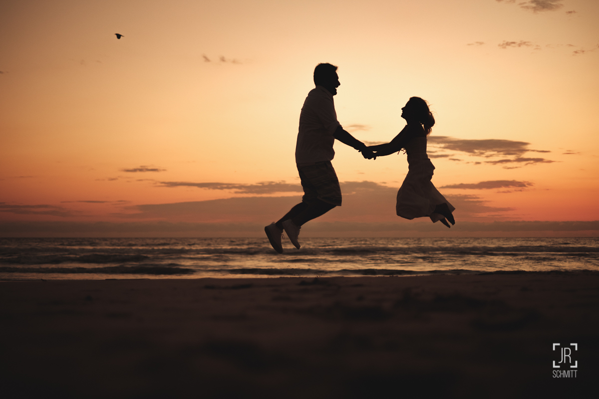 casal pulando sol nascendo
