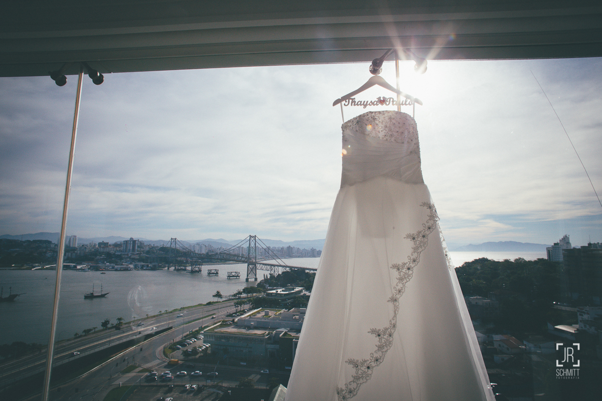 vestido da noiva pendurado na janela do hotel intercity com vista para  a ponte hercílio luz