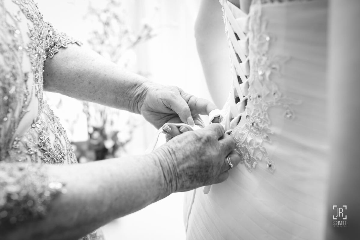 mãe da noiva amarrando o vestido