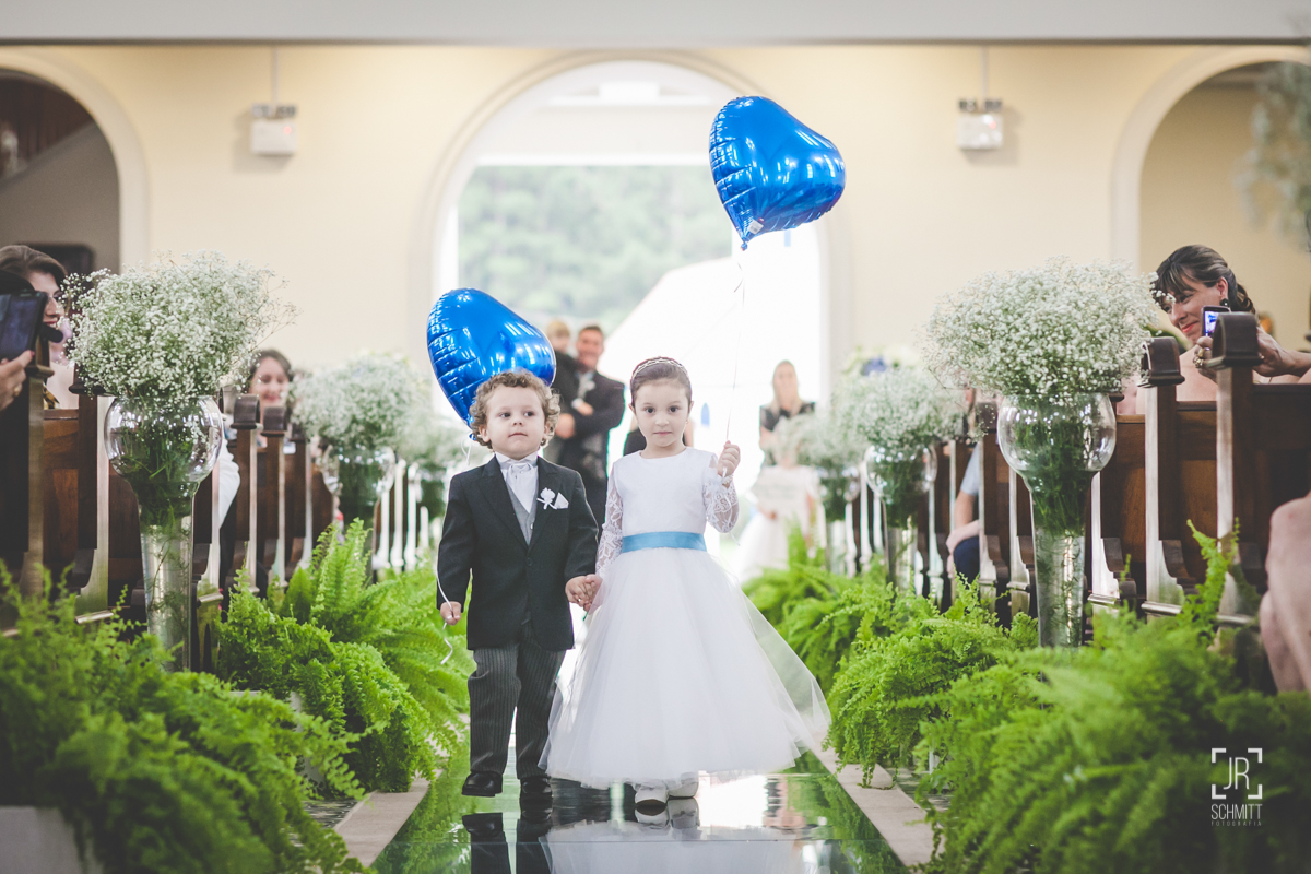 pajem e daminha segurando balões azuis
