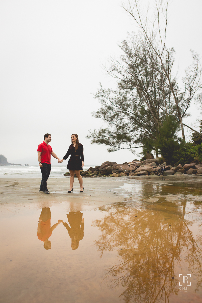 Casal de mãos dadas com reflexo na água