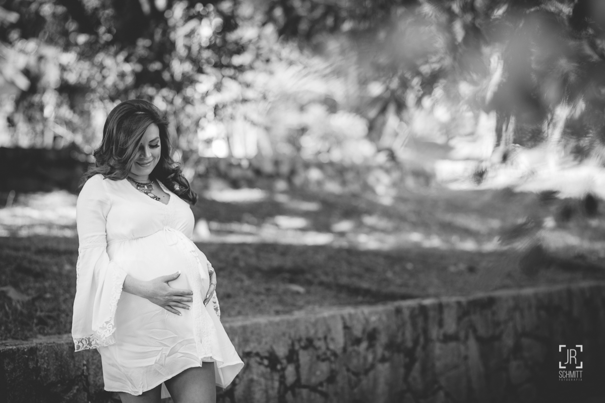 Grávida encostada no muro de pedras