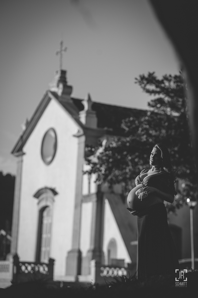 Gestante em preto e branco com a igreja de Santo Antônio de Lisboa ao fundo