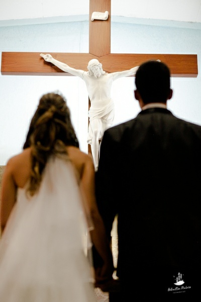 noivos sendo abençoado por jesus cristo na cruz 