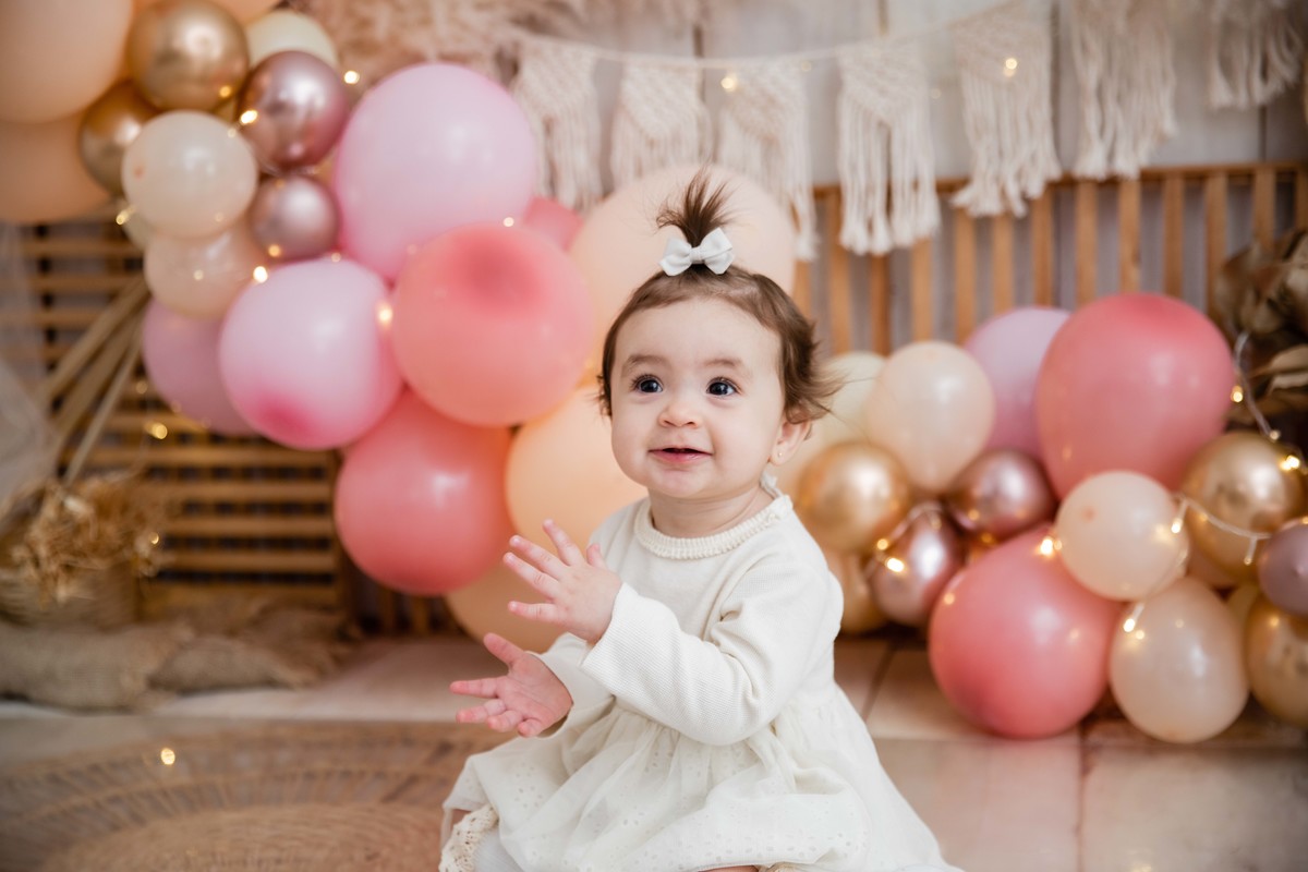 Bebe sentada batendo palmas cenário smash the cake boho chic sorrindo
