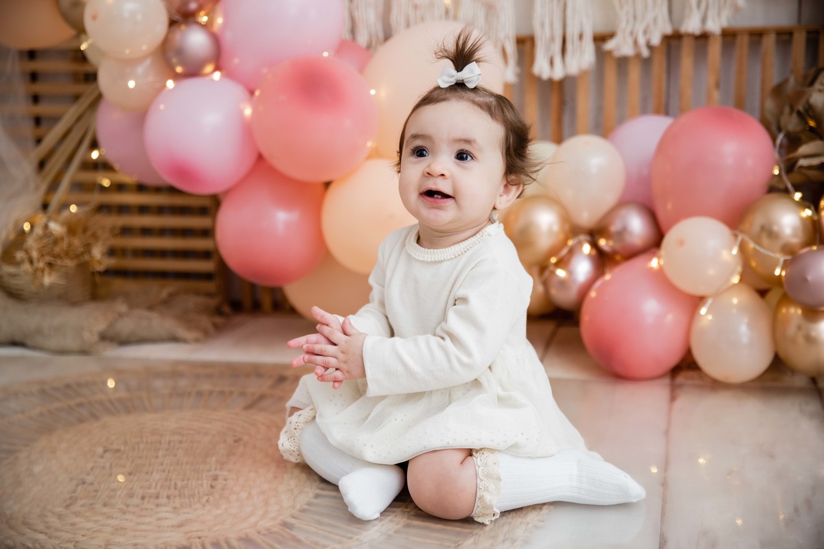 Bebe sentada batendo palmas cenário smash the cake boho chic sorrindo boquinha aberta