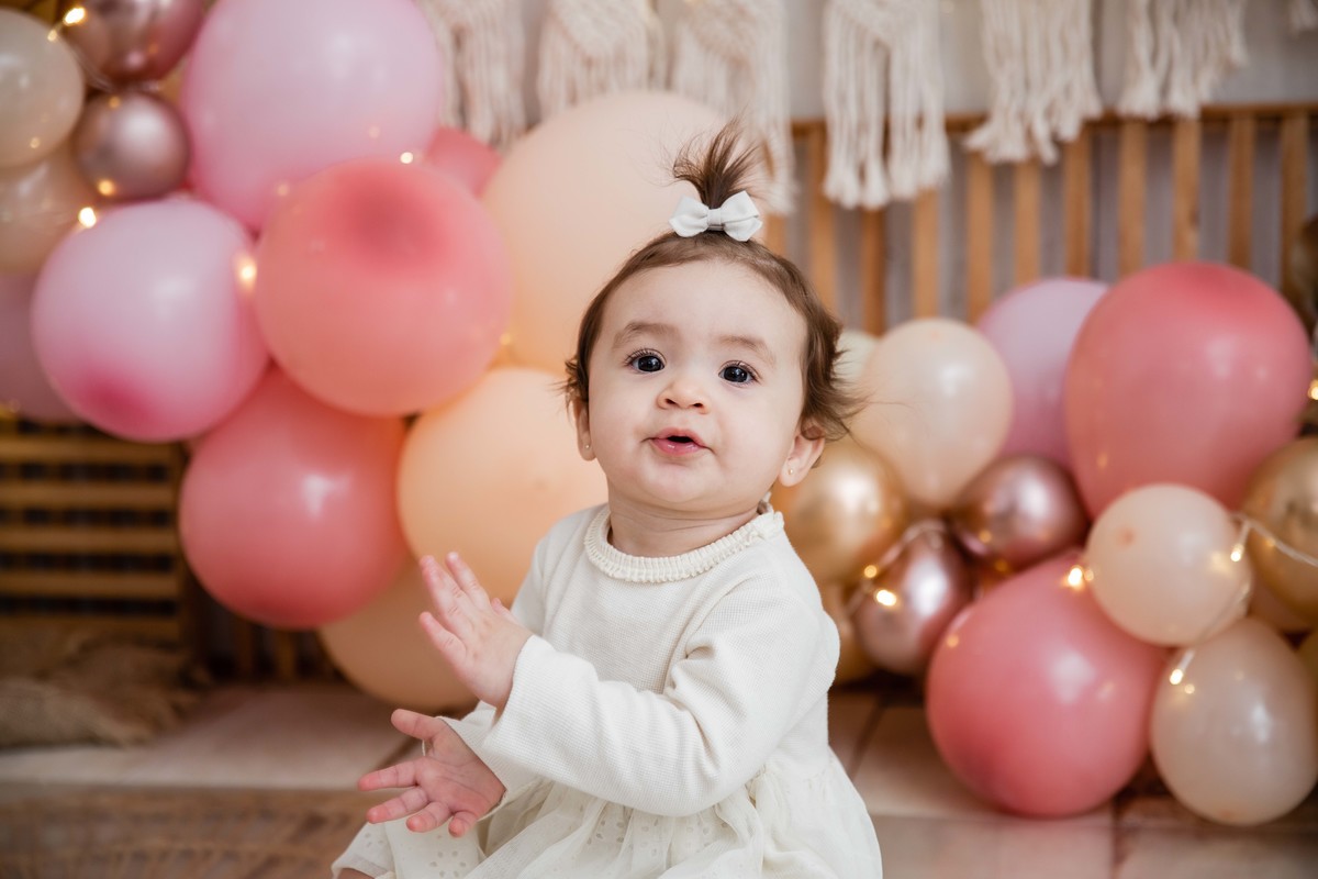 Bebe sentada batendo palmas cenário smash the cake boho chic sorrindo feliz