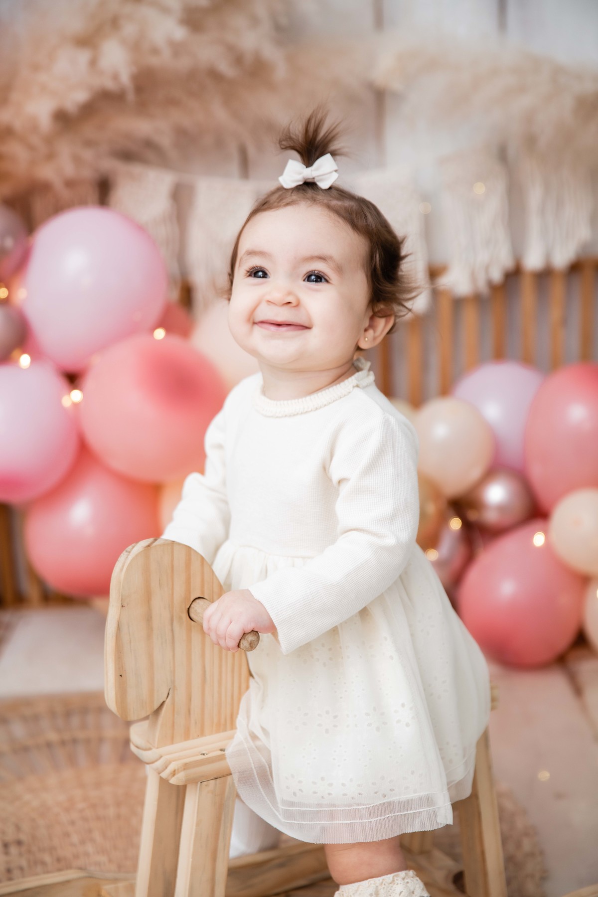 Bebe no cavalinho de balanço cenário smash the cake boho chic sorrindo foco