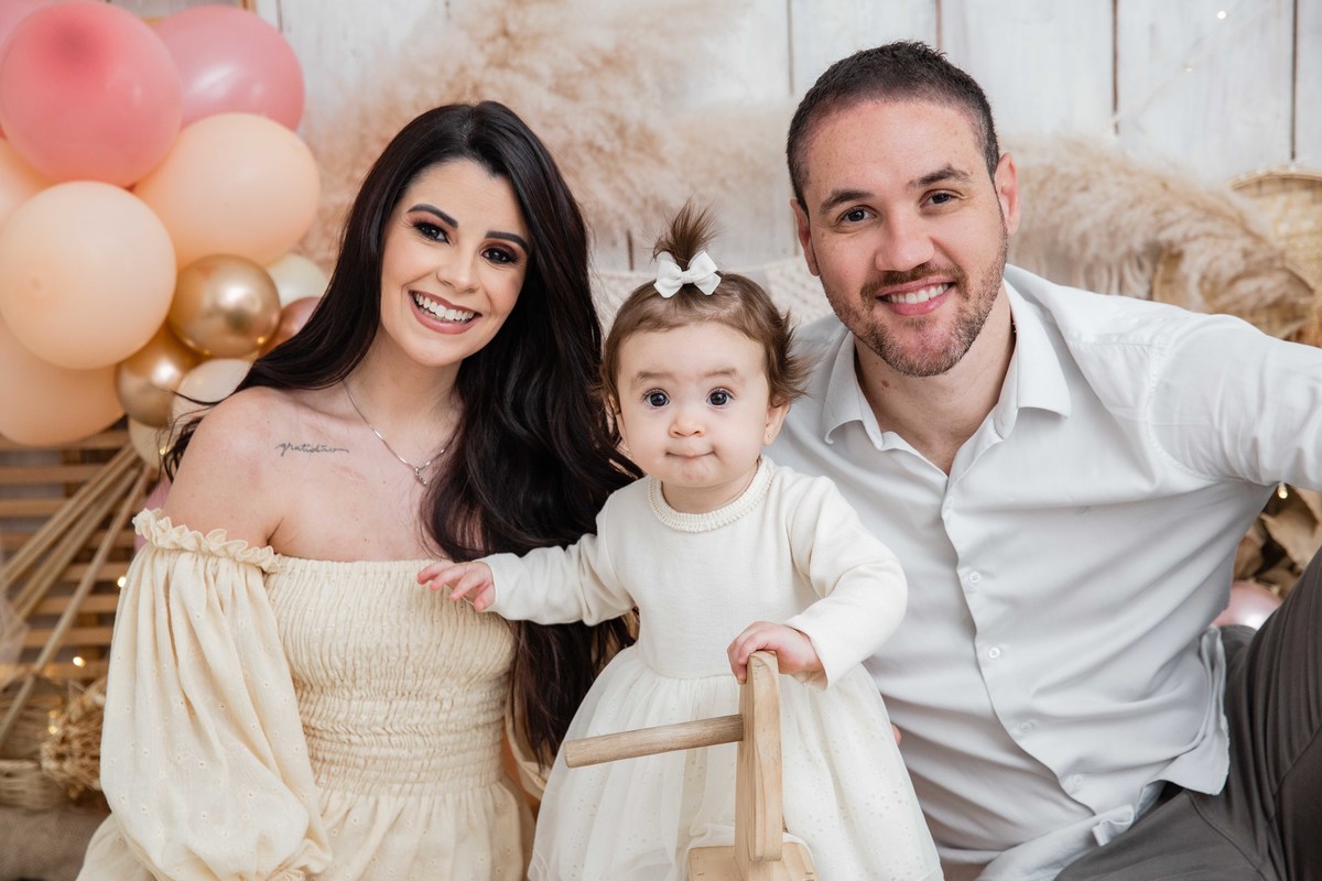 Bebe no cavalinho de balanço com os pais cenário smash the cake boho chic sorrindo