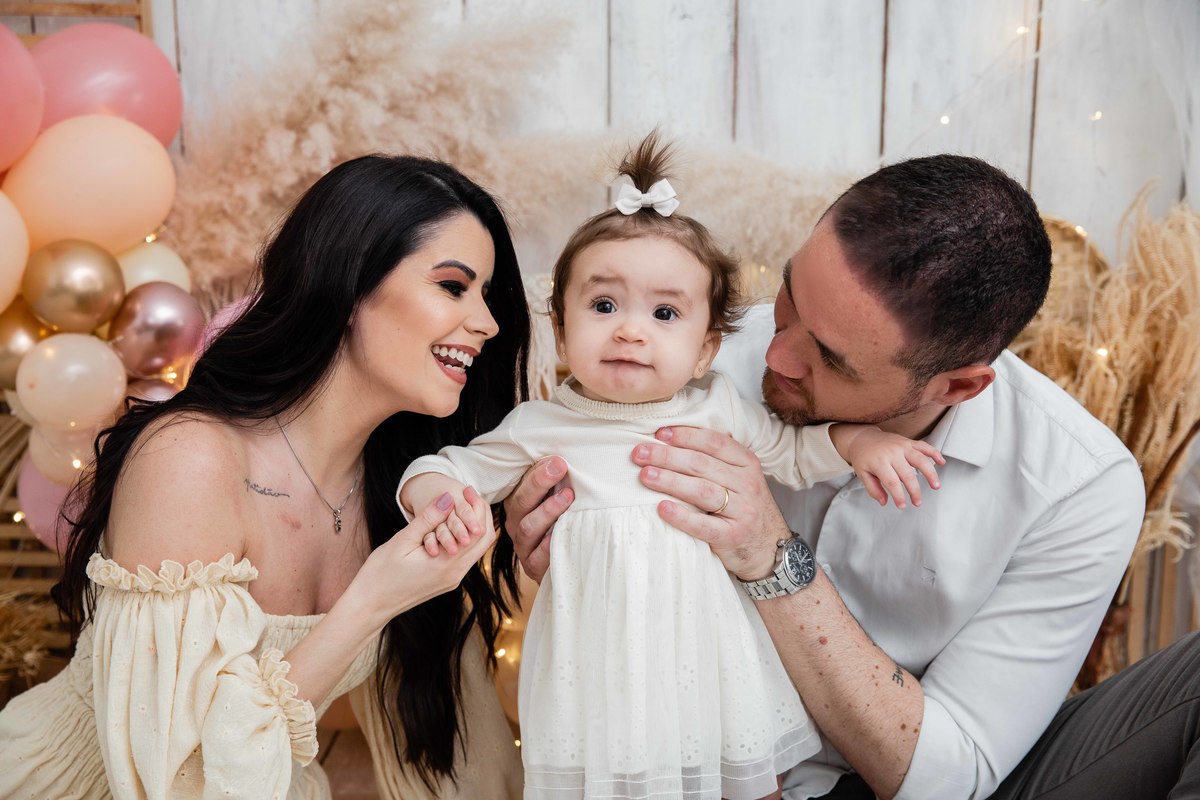 Bebe com os pais cenário smash the cake boho chic sorrindo com os pais em pé