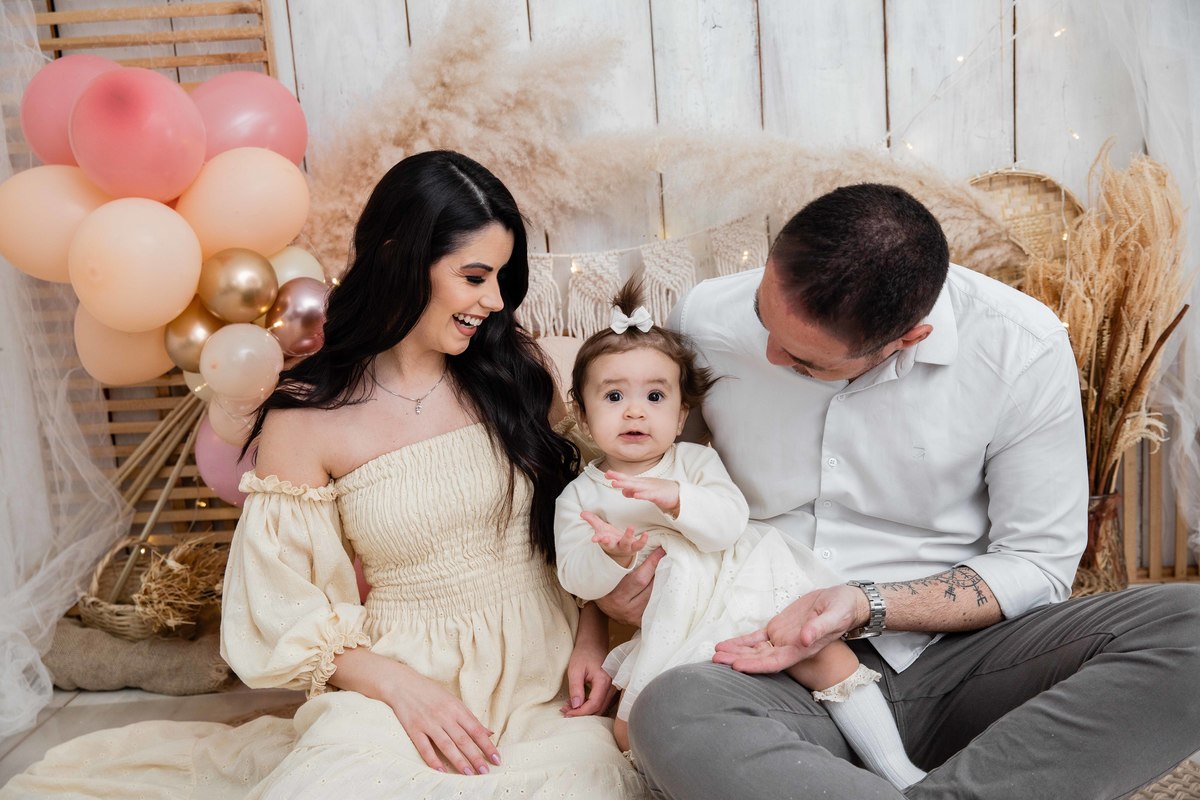 Bebe com os pais cenário smash the cake boho chic sorrindo com os pais no colo batendo palmas