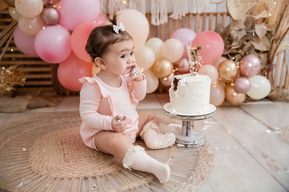 Bebe cenário smash the cake boho chic roupinha rosa comendo bolo bagunça com a mao na boca