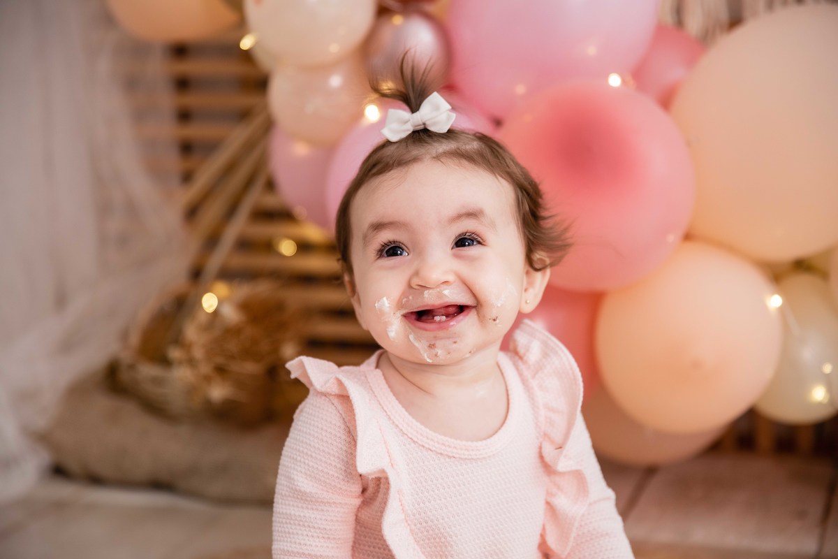 Bebe cenário smash the cake boho chic roupinha rosa comendo bolo bagunça boca lambuzada sorrindo