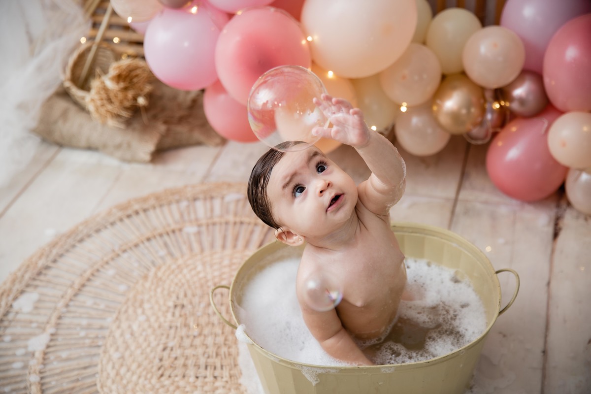 Bebe cenário smash the cake boho chic roupinha rosa no splash dentro da tina amarelinha feliz sorrindo olhando p cima pegando bolinha de sabão