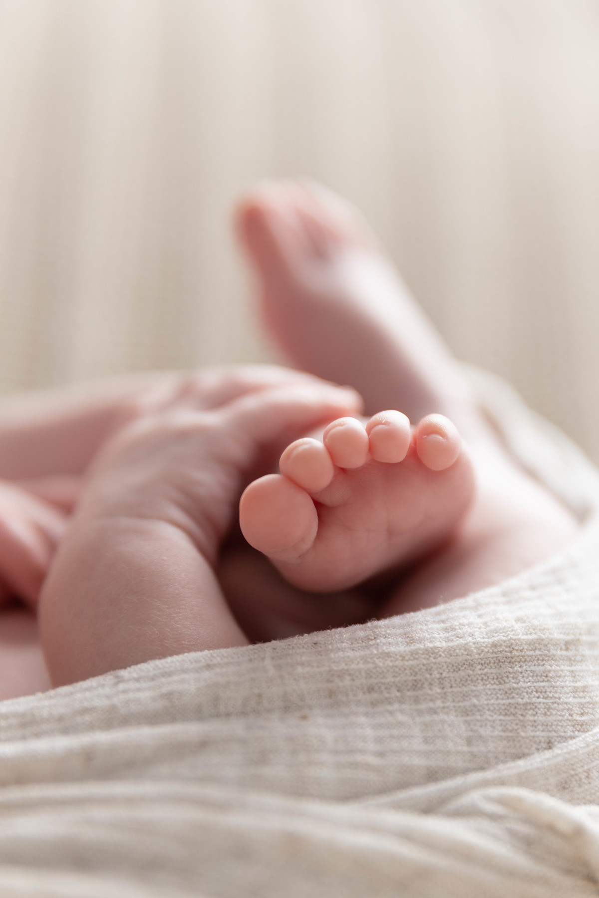 bebe deitado com mão no pézinho  no pufe