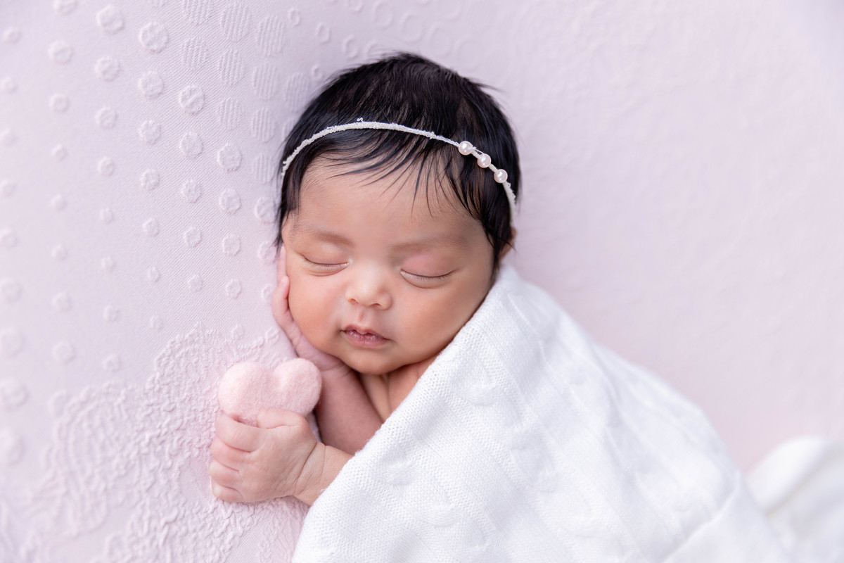 bebe enroladinha no colo dos pais