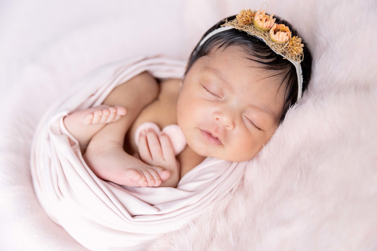 bebe enroladinha segurando coração