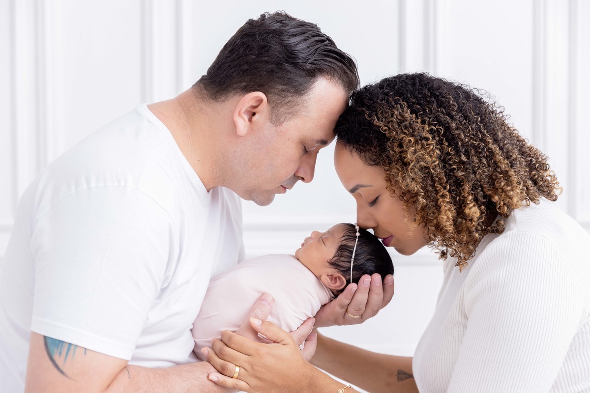 bebe enroladinha no colo dos pais