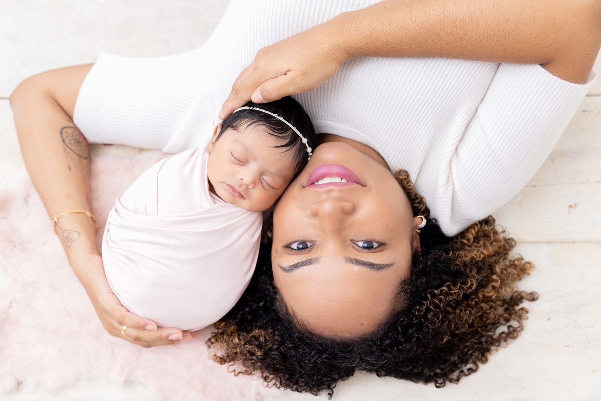 bebe enroladinha no braço da mãe deitadas na cama