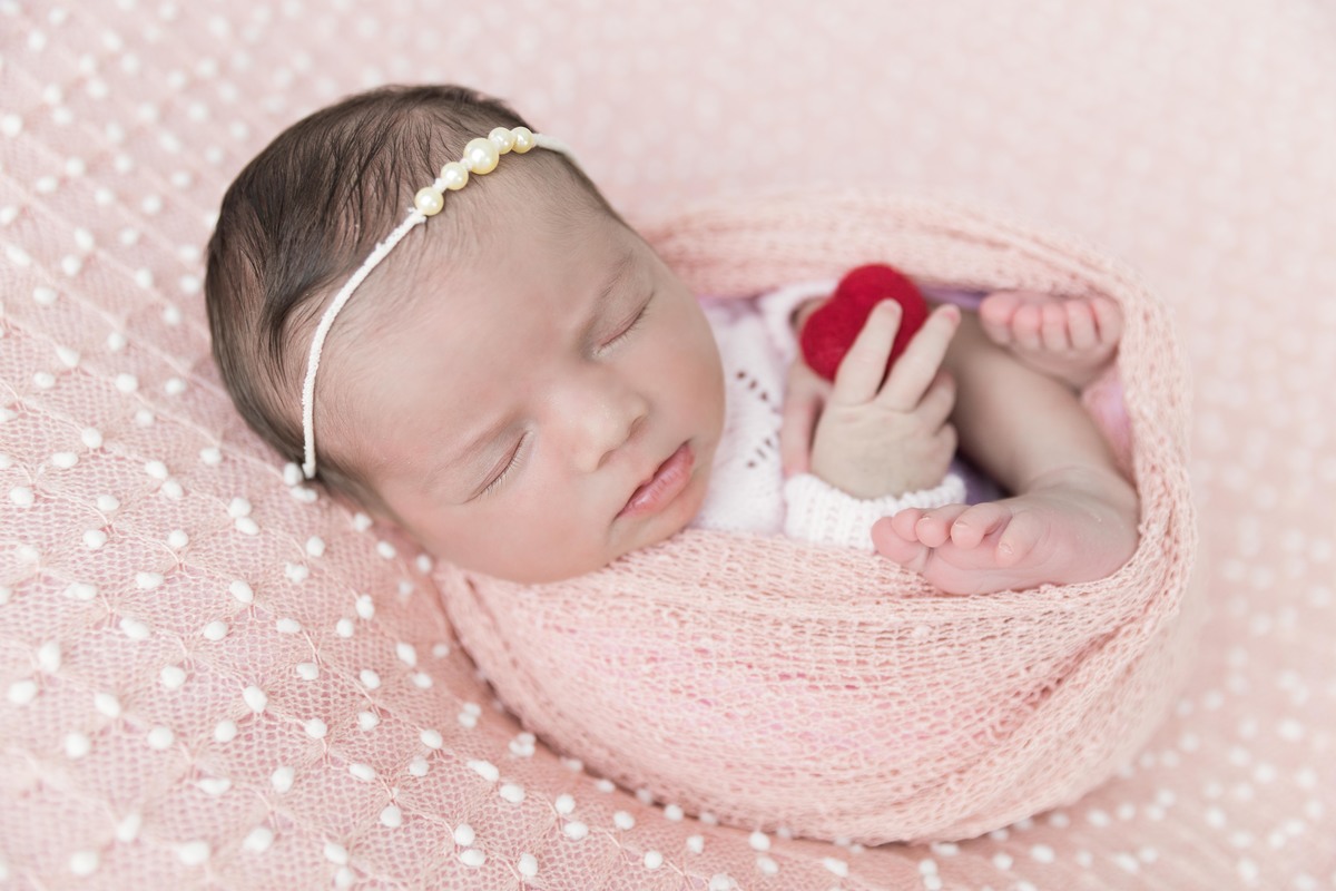 bebe enroladinha segurando coração