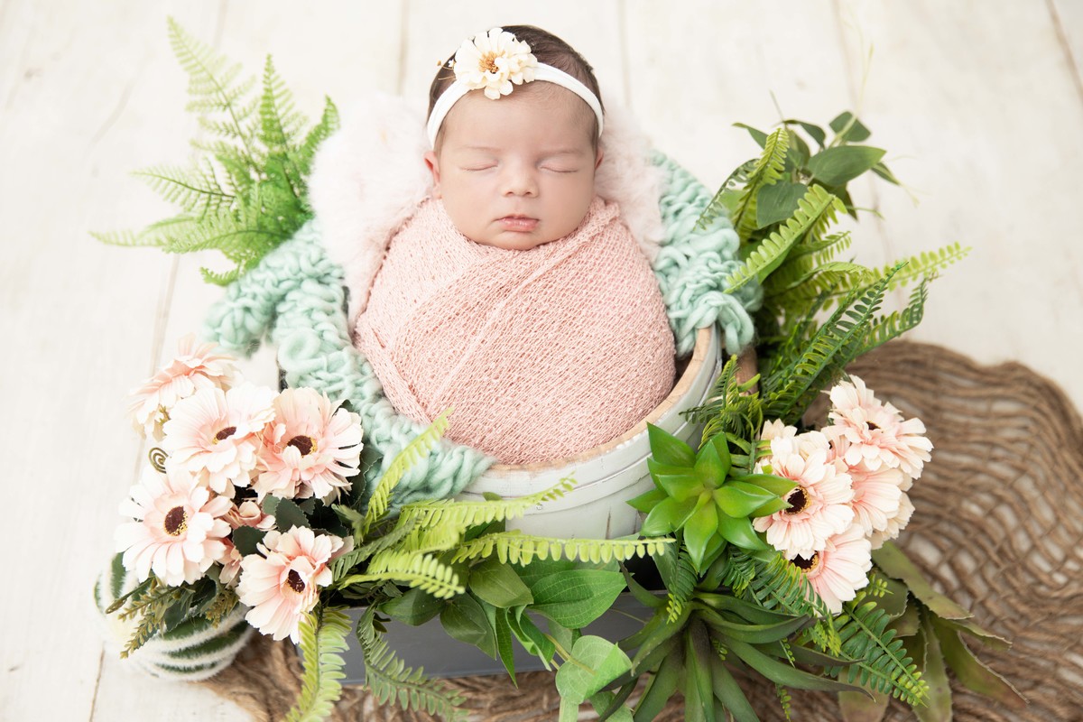 bebe enroladinha no balde com flores