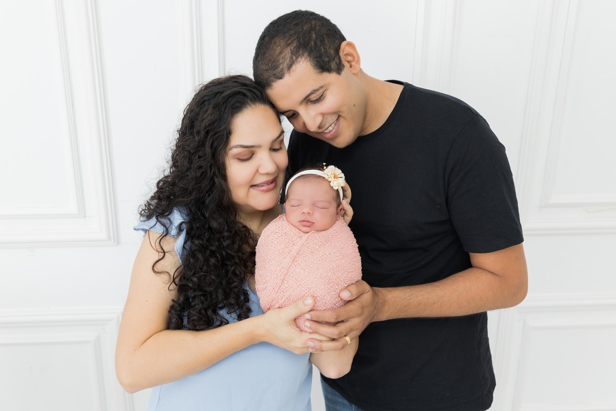 bebe enroladinha no colo dos pais