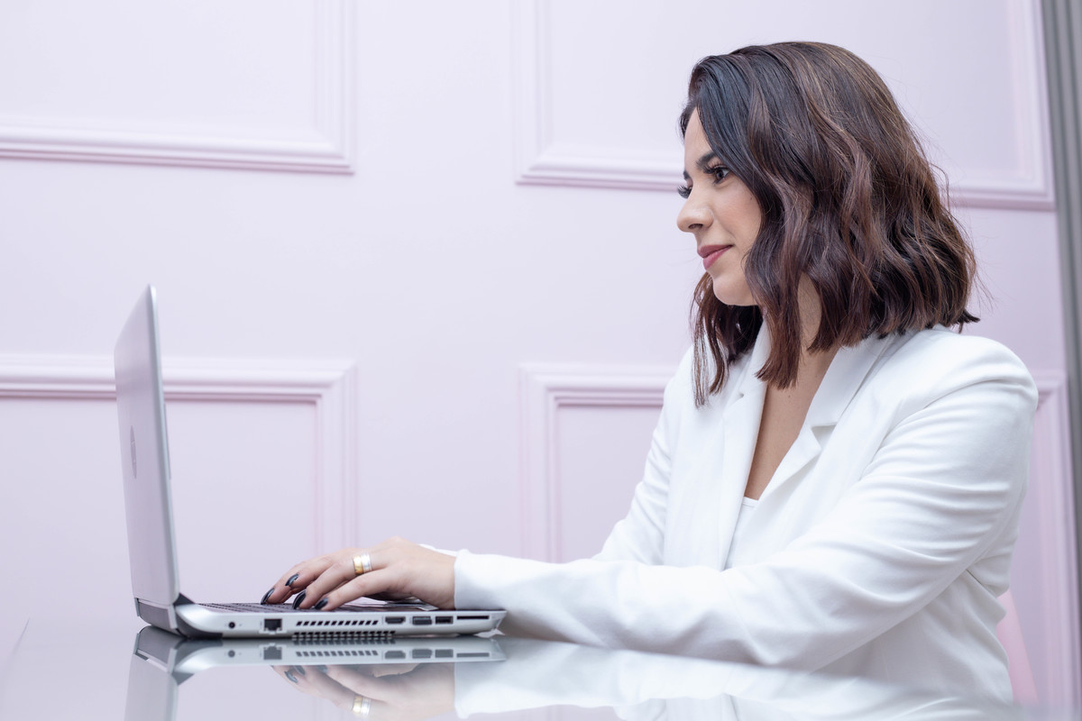 mulher blaser branco Coach em frente a computador