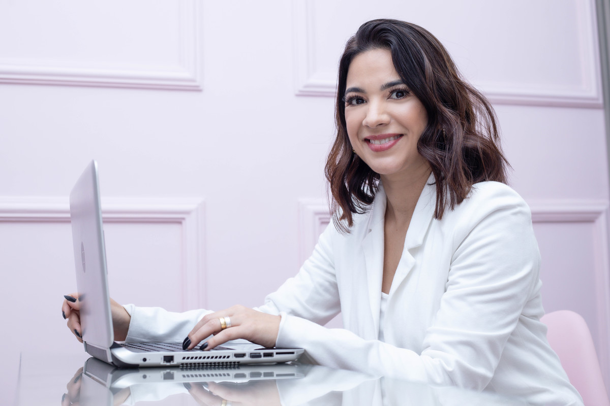 mulher blaser branco Coach em frente a computador sorrindo