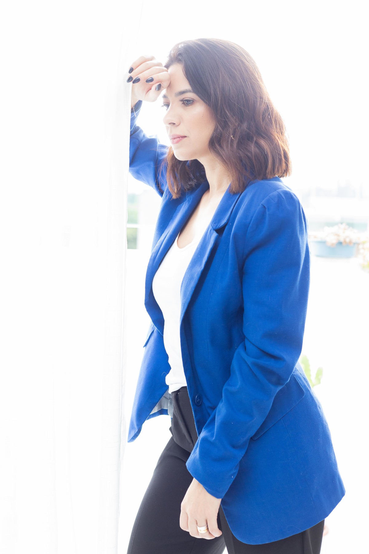 mulher blaser azul Coach em frente a janela