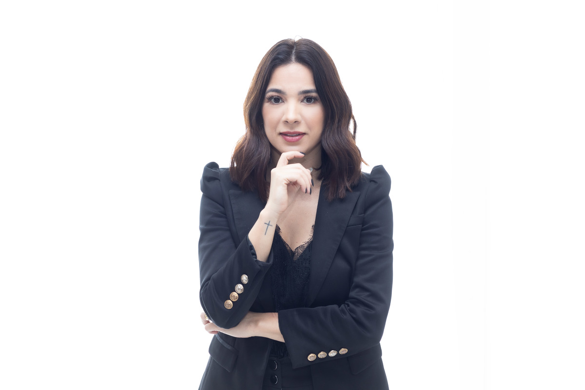 mulher blaser preto Coach pose de frente mao no queixo