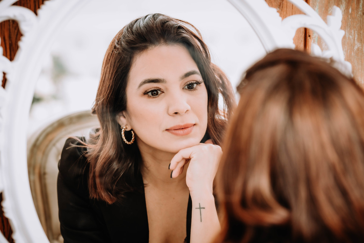 mulher blaser preto Coach em frente a espelho foto pertinho