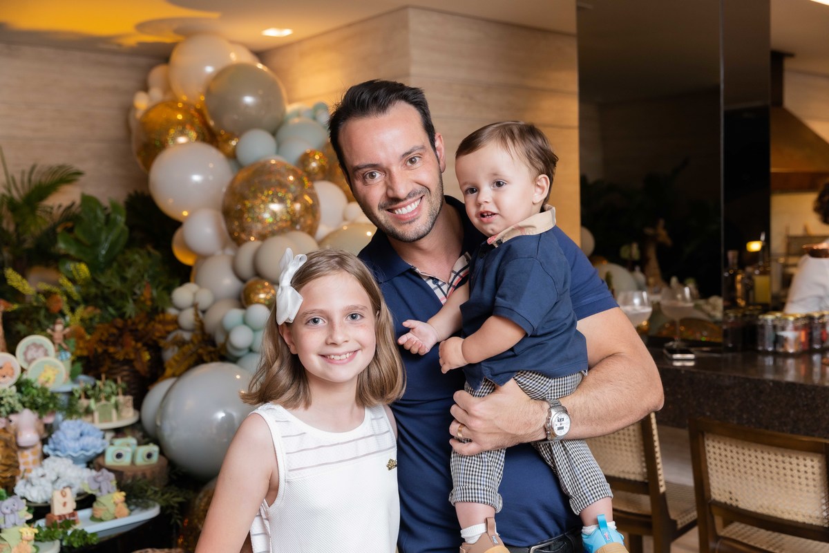 bebe no colo do pai na mesa do bolo tema safari  com prima