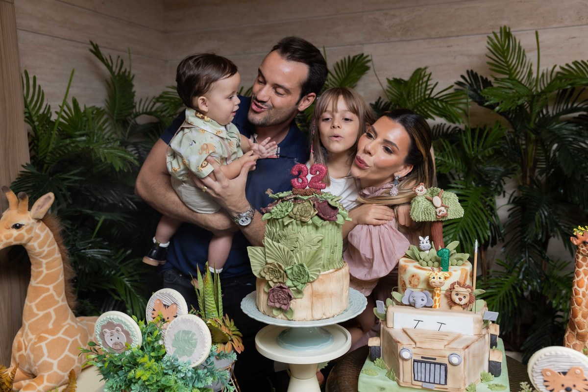 mae aniversariante em frente seu bolo lindo de cactos soprando as velinhas