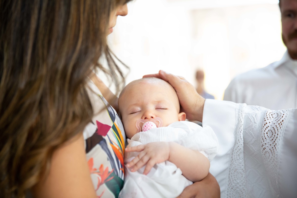 o padre fazendo carinho na batismanda