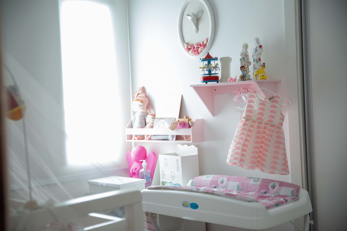 Quarto da bebe com vestido pendurado para usar ap;os o batismo
