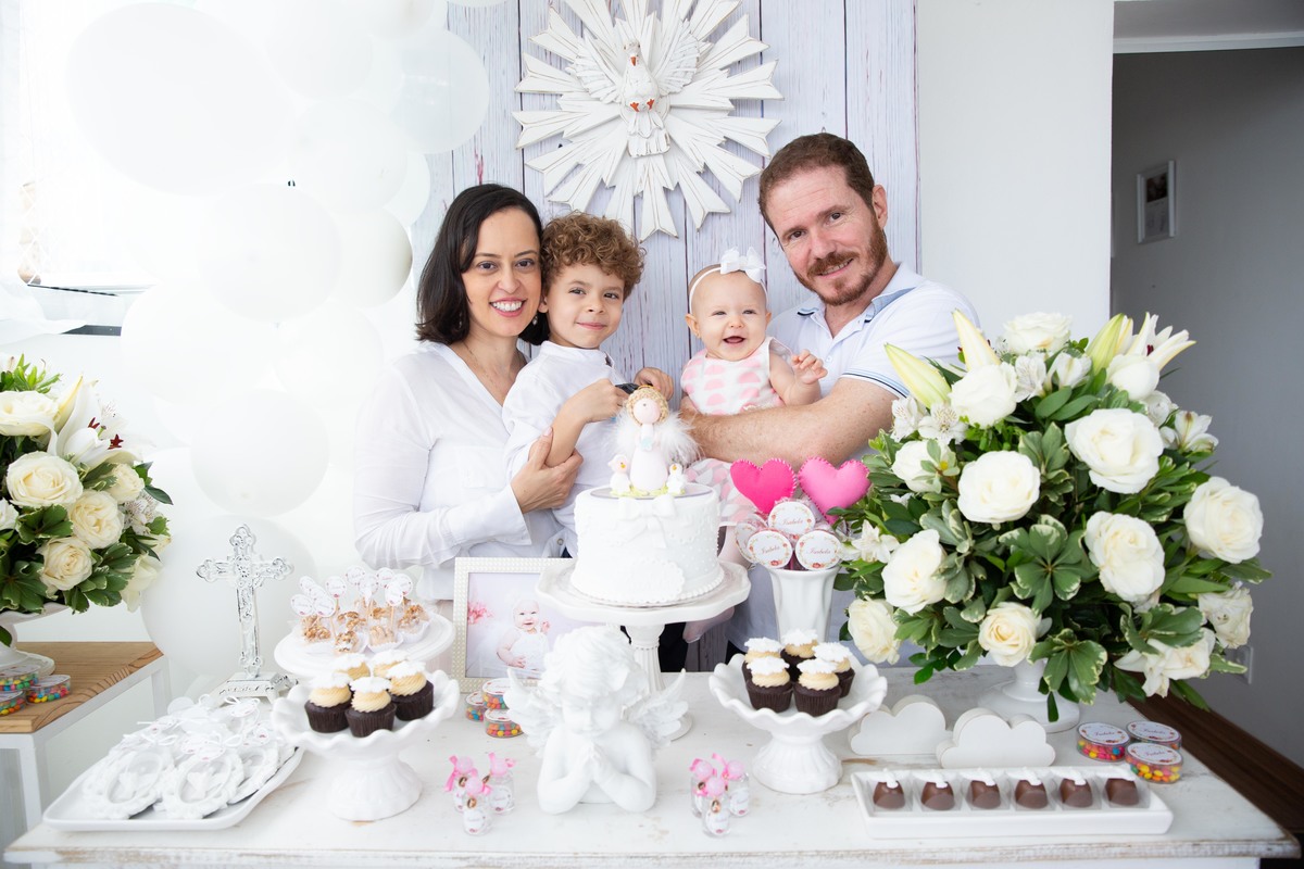 A bebe com seus pais e irmão em foto na mesa decorada