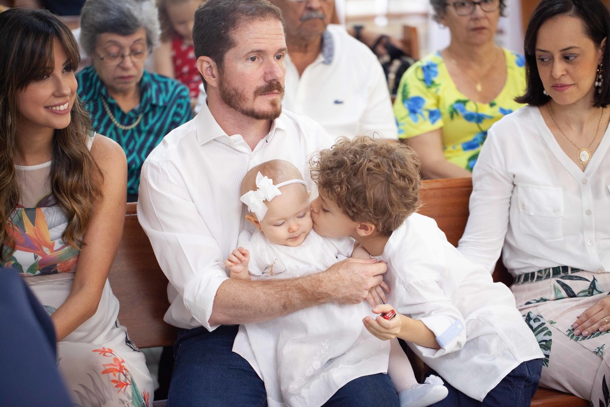 Carinho do irmão na irmãzinha, dando um beijinho durante a cerimônia