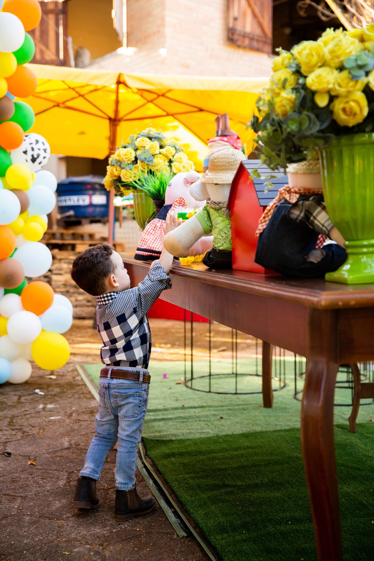 Aniversariante pego no flagra pegando docinho na mesa do bolo tema fazendinha na roça