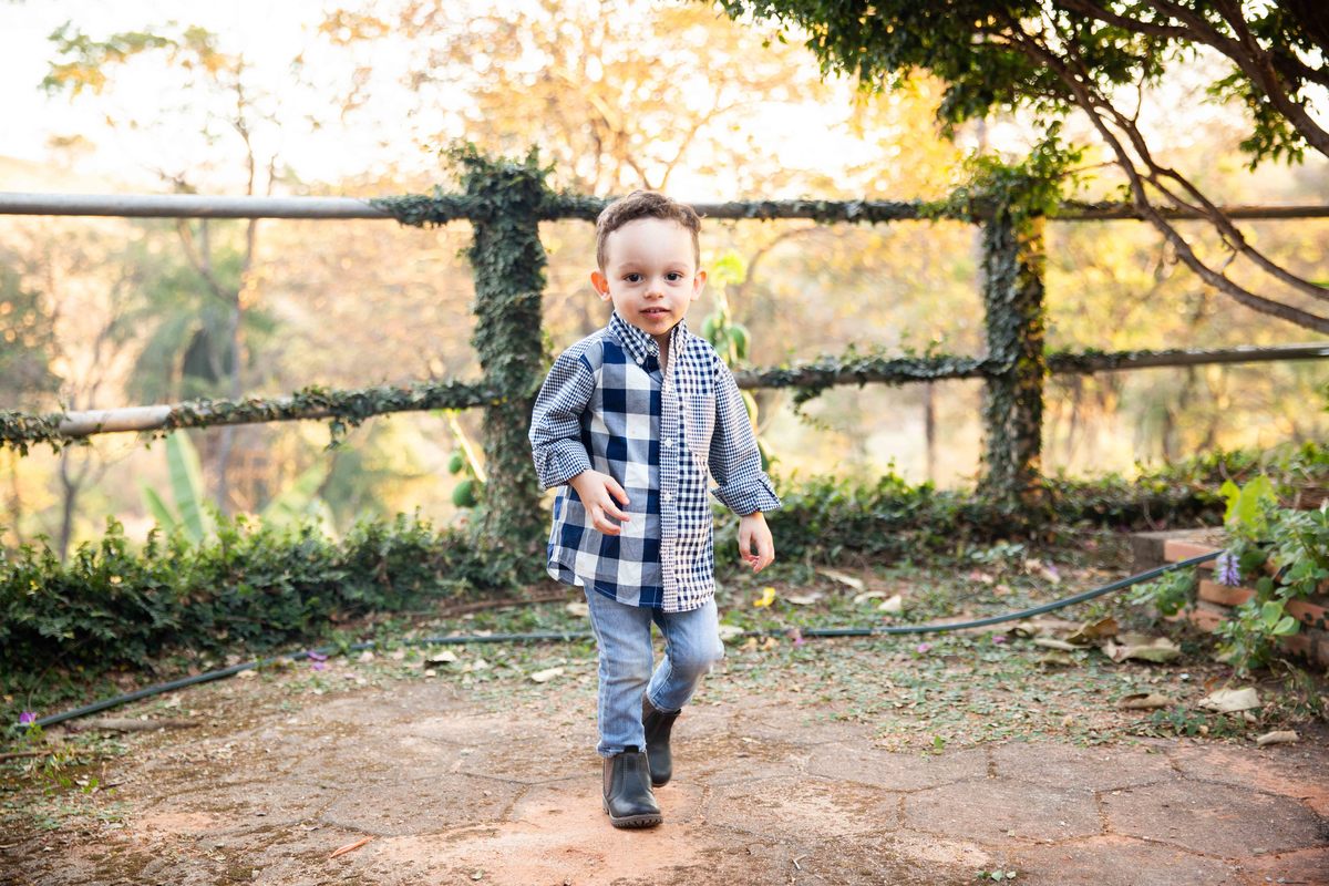 Aniversariante fazendo graça com  camisa xadrez  tema fazendinha na roça
