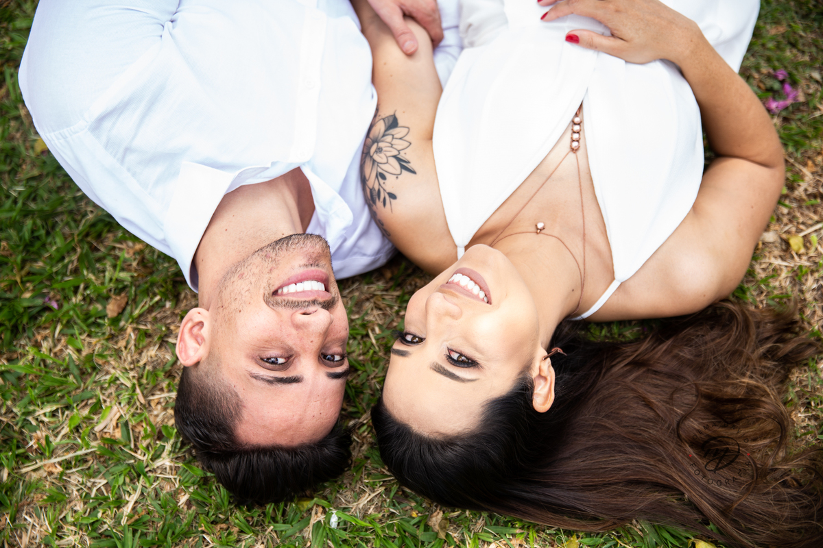 Casal deitado no chão na grama