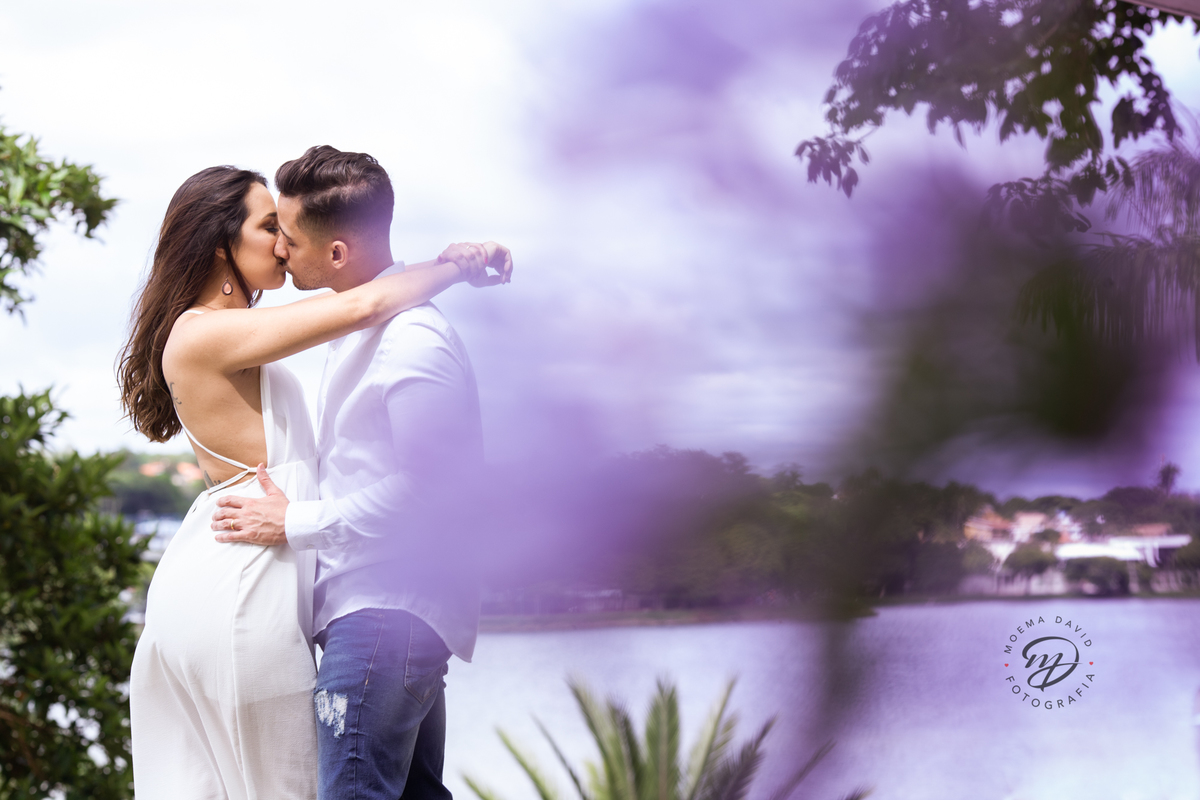 casal se bejando com sol natureza e flores lilas