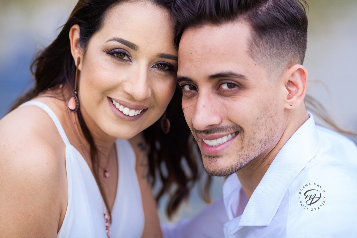 Casal abraçado juntinho olhando para a camera