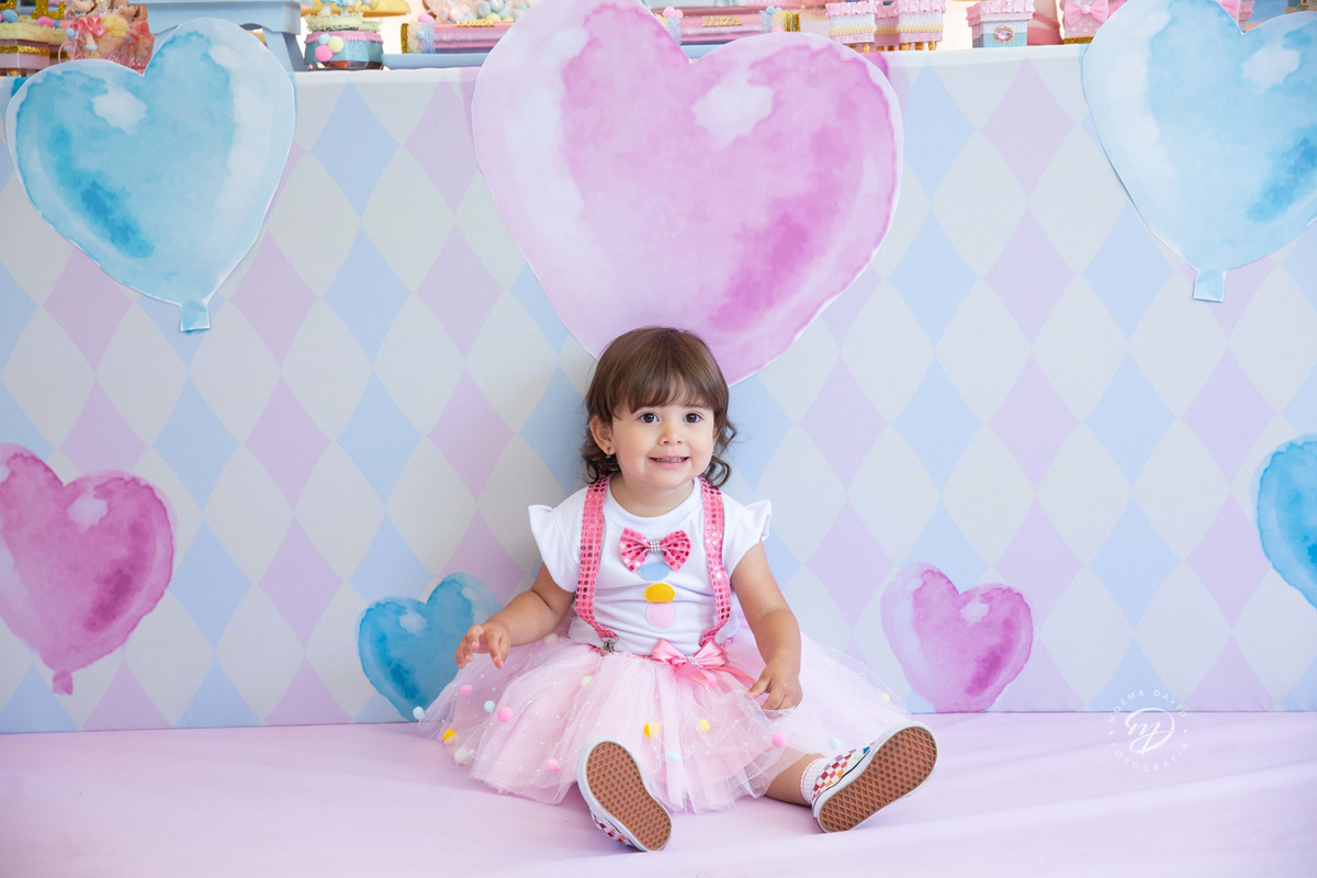 Festa infantil tema circo 2 anos menina rosa  dando sorriso sentada no chão