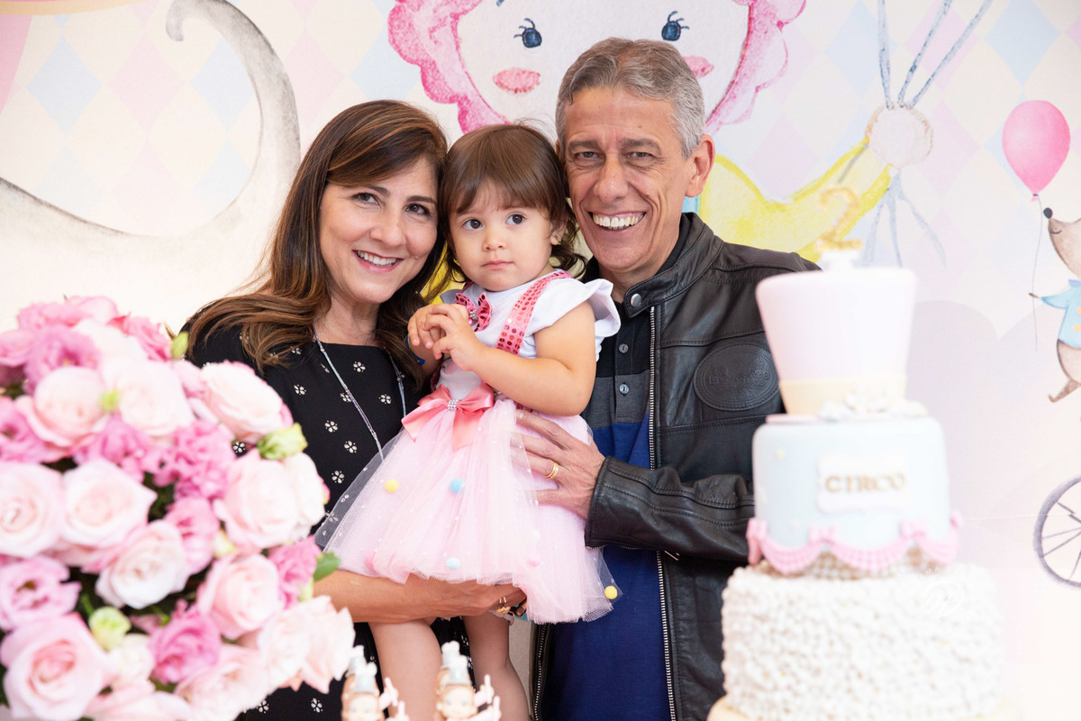 Festa infantil tema circo 2 anos menina rosa no colo dos avós vovô e vovó maternos