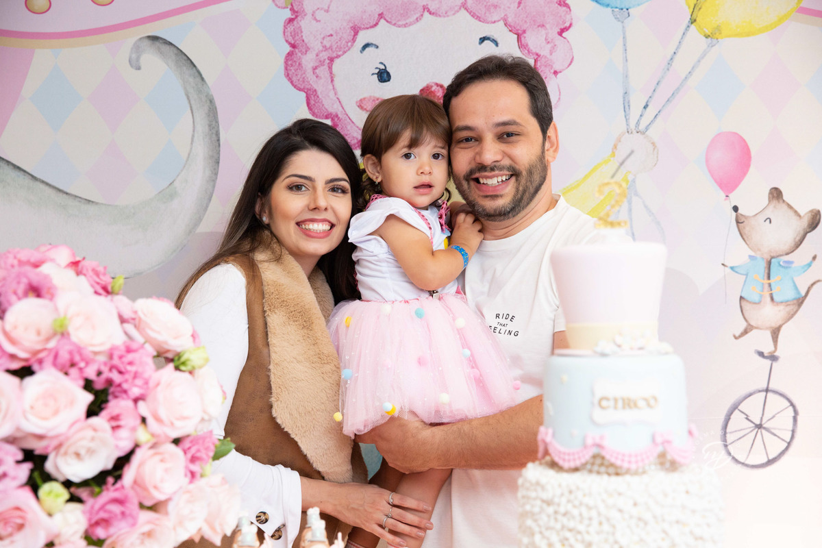 Festa infantil tema circo 2 anos menina rosa no colo dos pais papai e mamãe