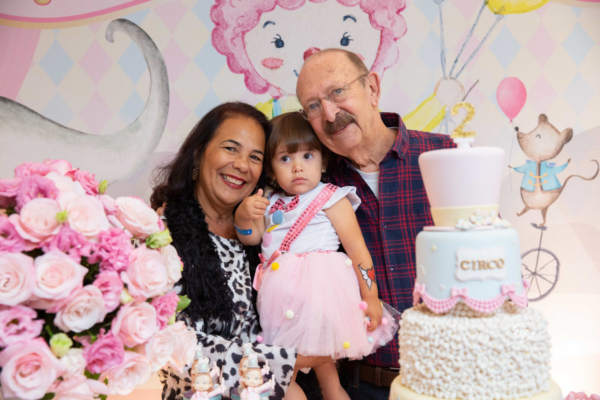 Festa infantil tema circo 2 anos menina rosa no colo dos avós vovô e vovó maternos